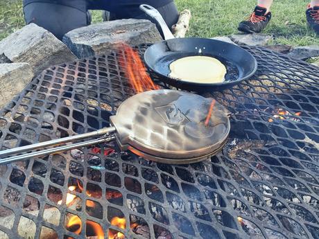 Vaffeljern og stekepanne med pannekaker på bålet
